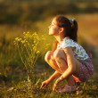 Girl inhales aroma of a wildflower