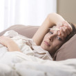 Woman lying sick in bed